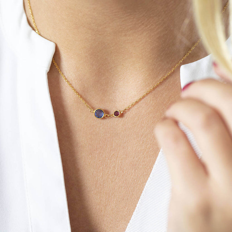 Image shows model wearing gold plated Mother and Child Birthstone Link Necklace. Birthstones from left to right for mother and child - March aquamarine and February purple amethyst.