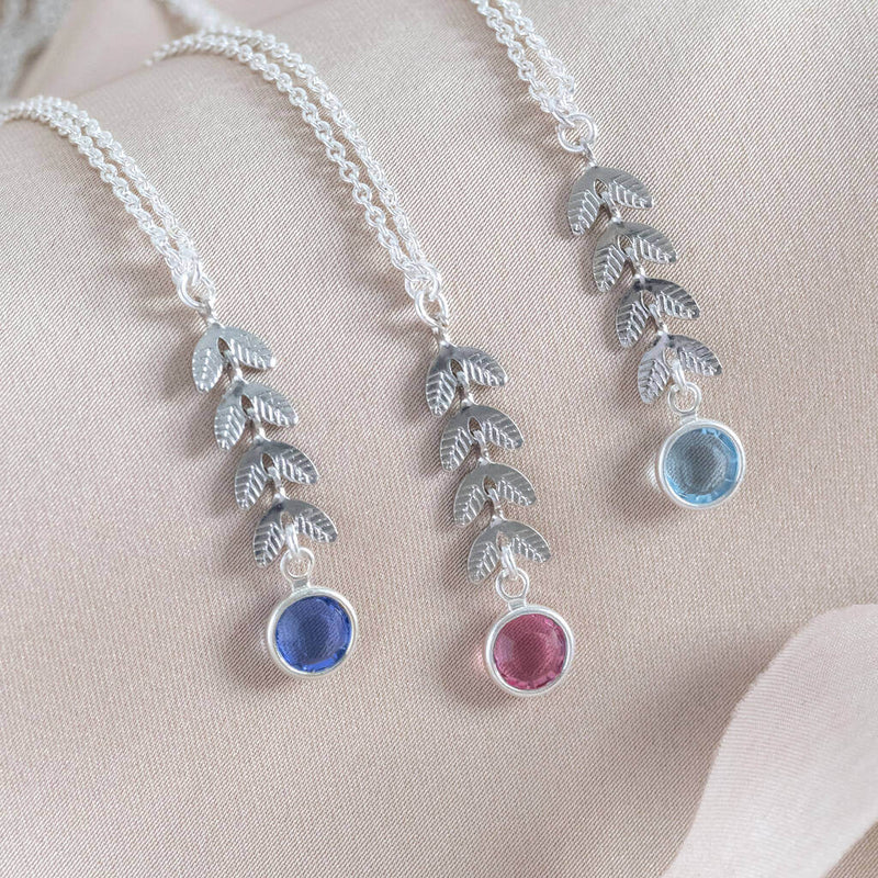 Image shows three silver Leaf Vine Necklaces each with a different birthstone. From left to right: September Sapphire, October Rose and March Aquamarine.