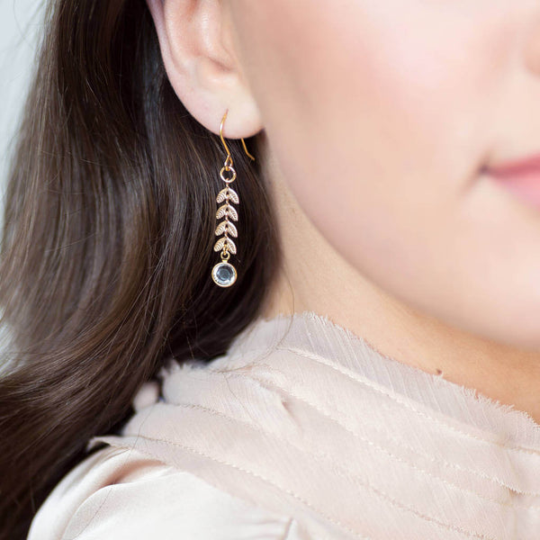 Model wears gold leaf vine earrings with April Crystal Swarovski Birthstone detail.