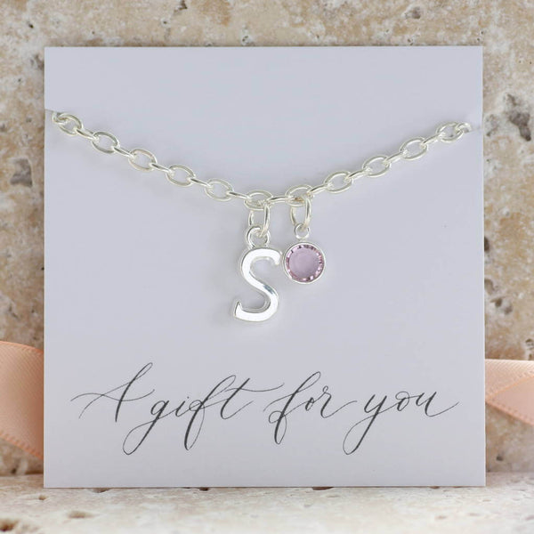 Image shows silver plated initial and charm bracelet on "A gift for you' sentiment card, with the initial 'S' and the June Light Amethyst Swarovski birthstone crystal.
