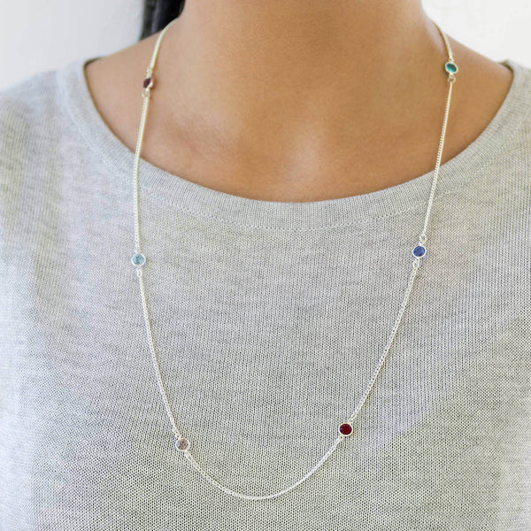 Model wears silver plated long family birthstone necklace with with six Swarovski birthstones