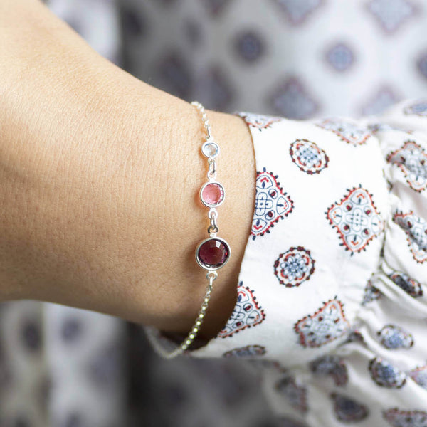 Model wears Sterling Silver Three Generations Birthstone Bracelet with the following birthstones from the bottom: February Amethyst, October Rose and April Crystal. 