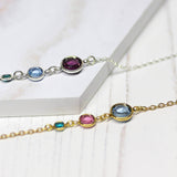 Image shows two of the Three Generation Birthstone Bracelets. Top is sterling silver with three birthstones from left to right: December Blue Zircon, March Aquamarine, February Amethysgold plated Three Generations Birthstone Bracelet with three birthstones. From left, December Blue Zircon, October Rose and March Aquamarine.