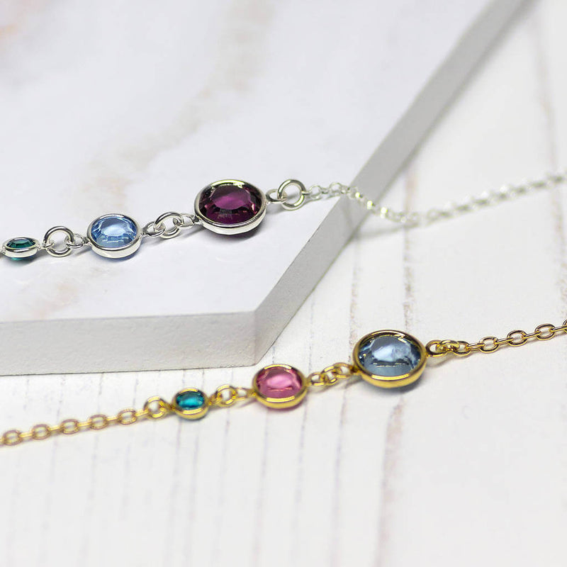 Image shows two of the Three Generation Birthstone Bracelets. Top is sterling silver with three birthstones from left to right: December Blue Zircon, March Aquamarine, February Amethysgold plated Three Generations Birthstone Bracelet with three birthstones. From left, December Blue Zircon, October Rose and March Aquamarine.