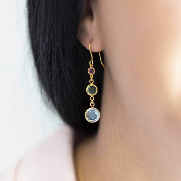 Model wears gold plated Three Generations Birthstone Earrings. Birthstones from bottom to top selection order: March Aquamarine, August Peridot and October Rose. Also available in Silver.