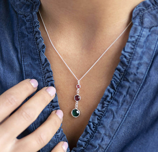 Model wears Sterling Silver Three Generations Birthstone Necklace. Birthstones from bottom to top (selection order) September Sapphire, February Amethyst, October Rose.