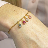 model wears charm bracelet with family birthstones.