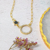 image shows crystal moon gold plated necklace with black star charm detail on a white background.