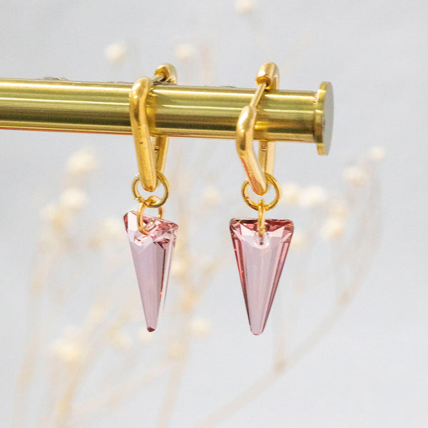 Image shows ero gold plated triangle huggie earrings with swarovski crystal in pink.