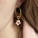 Image shows model wearing beaded daisy birthstone hoop earrings