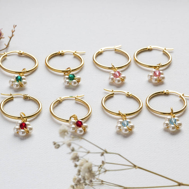 Image shows a selection of beaded daisy birthstone hoop earrings