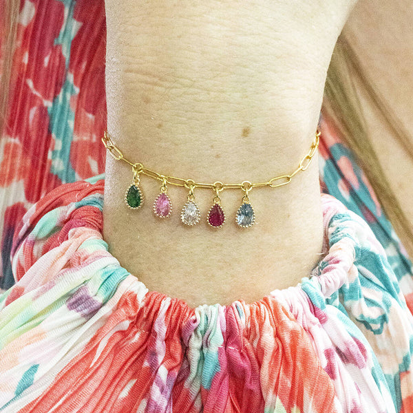 Model wears gold plated chain bracelet with teardrop shaped family birthstone charms