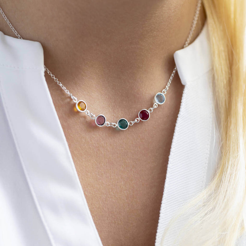 Model wears a silver Family Birthstone Link Necklace with five Swarovski Birthstone Crystals; yellow topaz, purple amethyst, green emerald, red garnet and aquamarine to represent the birth months November, February, May, January and March.