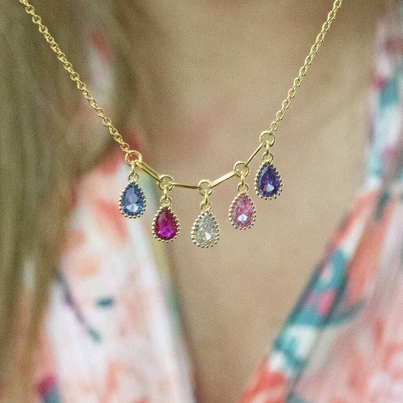 model wears family birthstone necklace with teardrop crystals. Five birthstones to represent five family members or loved ones.