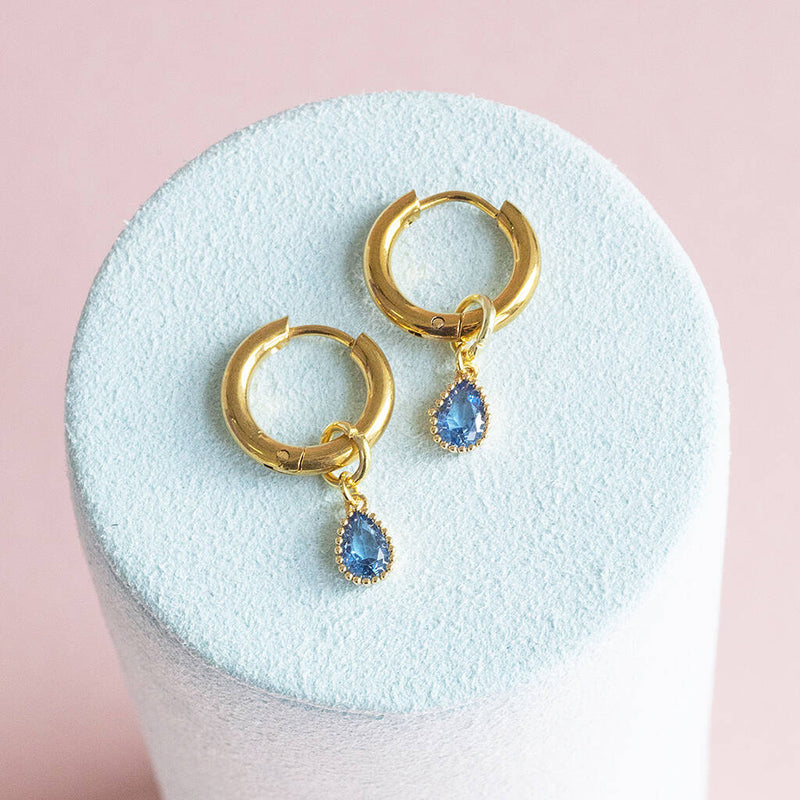 Image show gold plated huggie hoop earrings with december birthstones