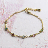 Image shows mini gold family birthstone bracelet with six mini Swarovski Birthstones (up to eight can be selected) Birthstones from left to right are; April Crystal, May Emerald, July Ruby, March Aquamarine, October Rose, August Peridot.