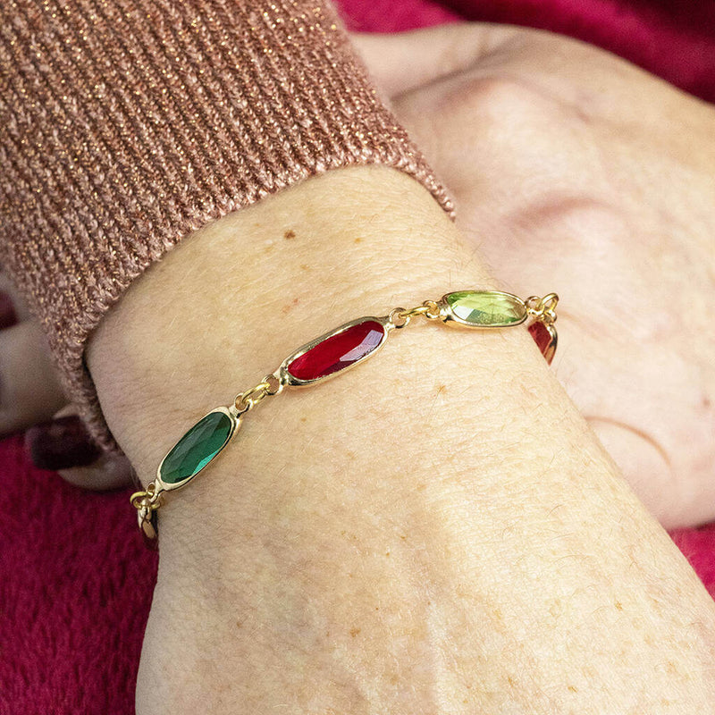 model wears gold plated oval link family birthstone bracelet.