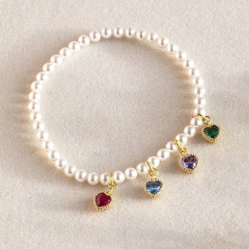 model wears pearl bracelet with family birthstone hearts.