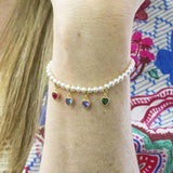 model wears pearl bracelet with family birthstone hearts.