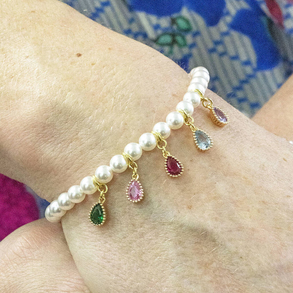 model wears a beaded pearl stretch bracelet with family members birthstone charms