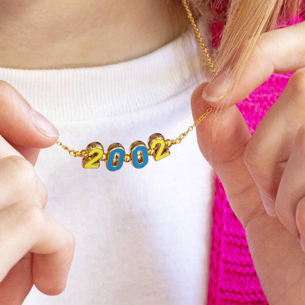 Image shows model holding personalised enamel significant date necklace