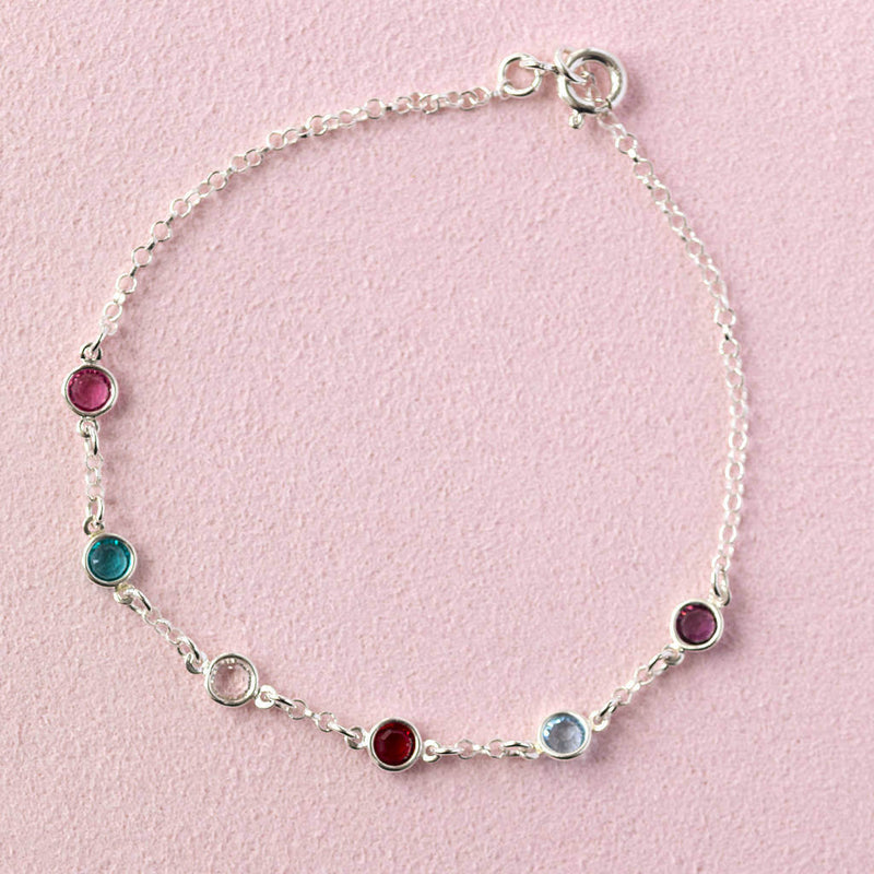 Sterling silver mini family birthstone bracelet with six birthstones (up to eight can be selected) from left to right birthstones are October Rose, May Emerald, April Crystal, July Ruby, March Aquamarine and February Amethyst.