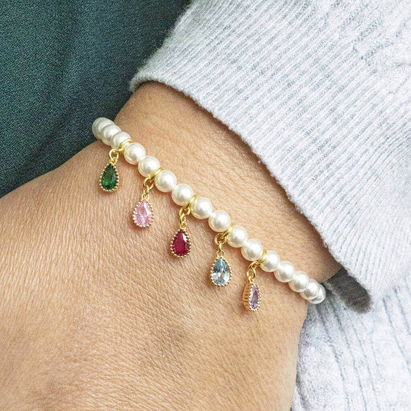 model wears pearl bracelet with family birthstone teardrops. Five birthstones appear here to represent different family members.