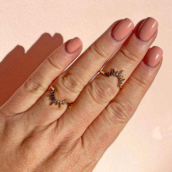 model wears gold plated sol duo ring set worn together on the different fingers to represent the sunrise and sunset.