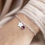Model wears Sterling silver initial star birthstone bracelet with February amethyst Swarovski crystal charm, and sterling silver star charm with a hand stamped initial 'K'.