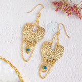 Image shows vega statement earrings with golden pave full moon, complete with chains and an indigo bead. Sat on a white backdrop.